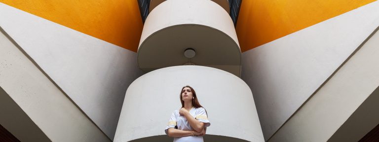 Documentation infrarouge 10 Portrait grand angle d'une modèle en contre-plongée devant une façade urbaine.