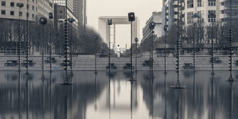 Jeune homme en costume perdu dans un environnment urbain. Photographie en ultraviolet issue de la série Echo Urbain et réalisée par le photographe Pierre-Louis Ferrer, spécialiste en photographie dans l'ultraviolet et l'infrarouge.
