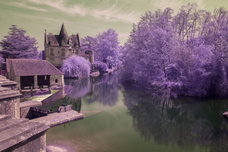 Image brute d'un traitement en aerochrome numérique, présentant le moulin de Moret sur Loing entouré de végétation rouge. Photographie en infrarouge réalisée par Pierre-Louis Ferrer.