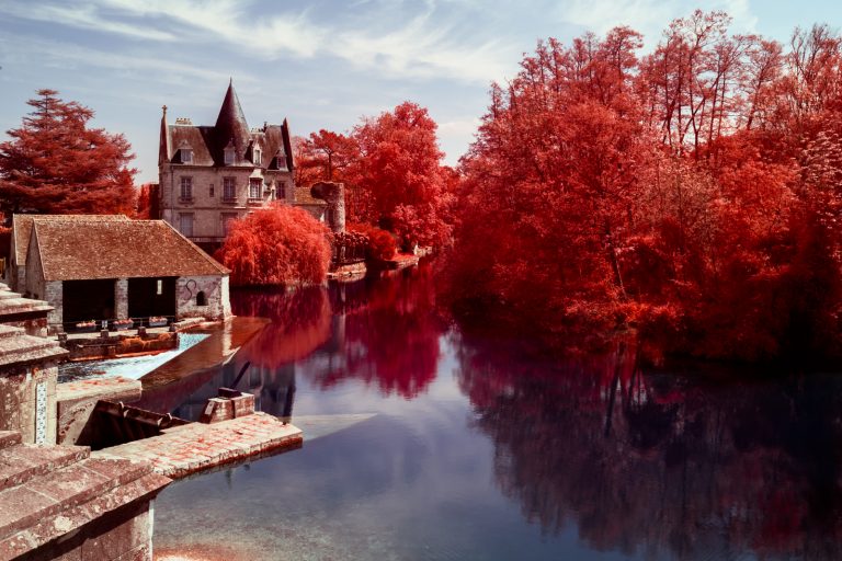 Résultat final d'un traitement en aerochrome numérique, présentant le moulin de Moret sur Loing entouré de végétation rouge. Photographie en infrarouge réalisée par Pierre-Louis Ferrer.